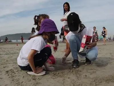 Estudantes de Santos dão aula de consciência ambiental e ajudam a limpar praia